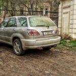 автомобиль припаркованный на уничтоженной траве в парке Шевченко